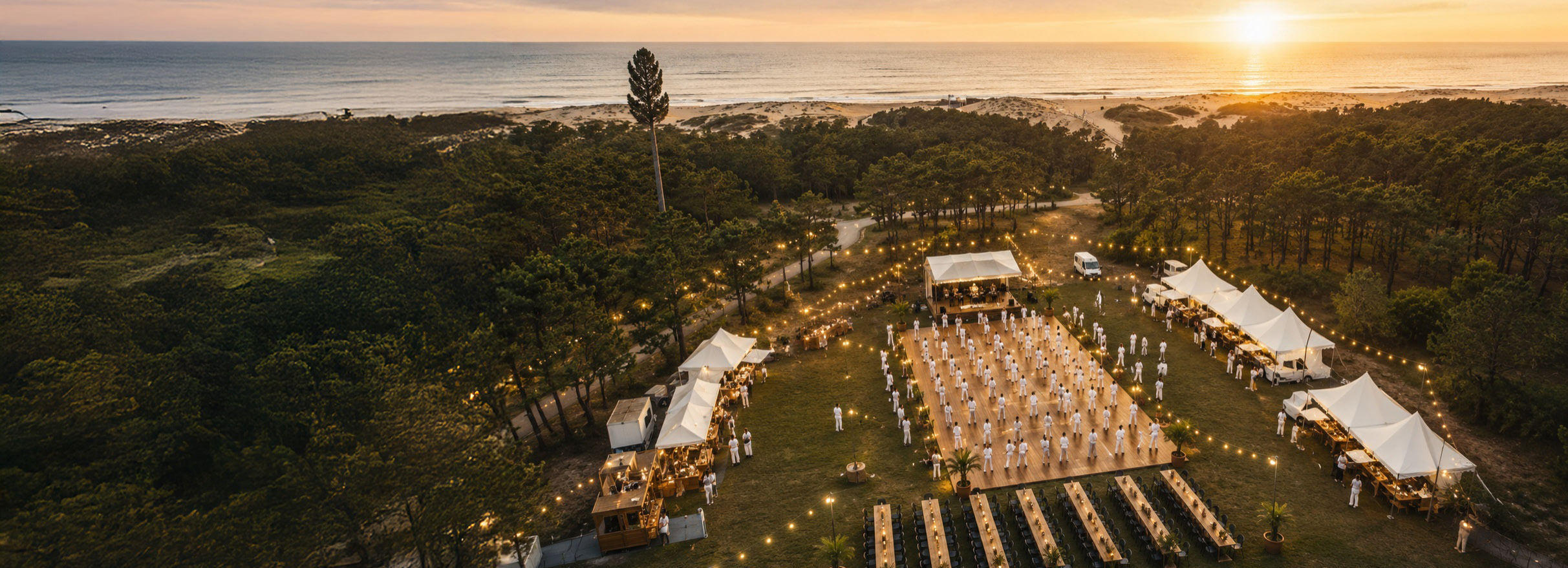Vue aérienne du festival au coucher du soleil, entre la forêt de pins et l'océan