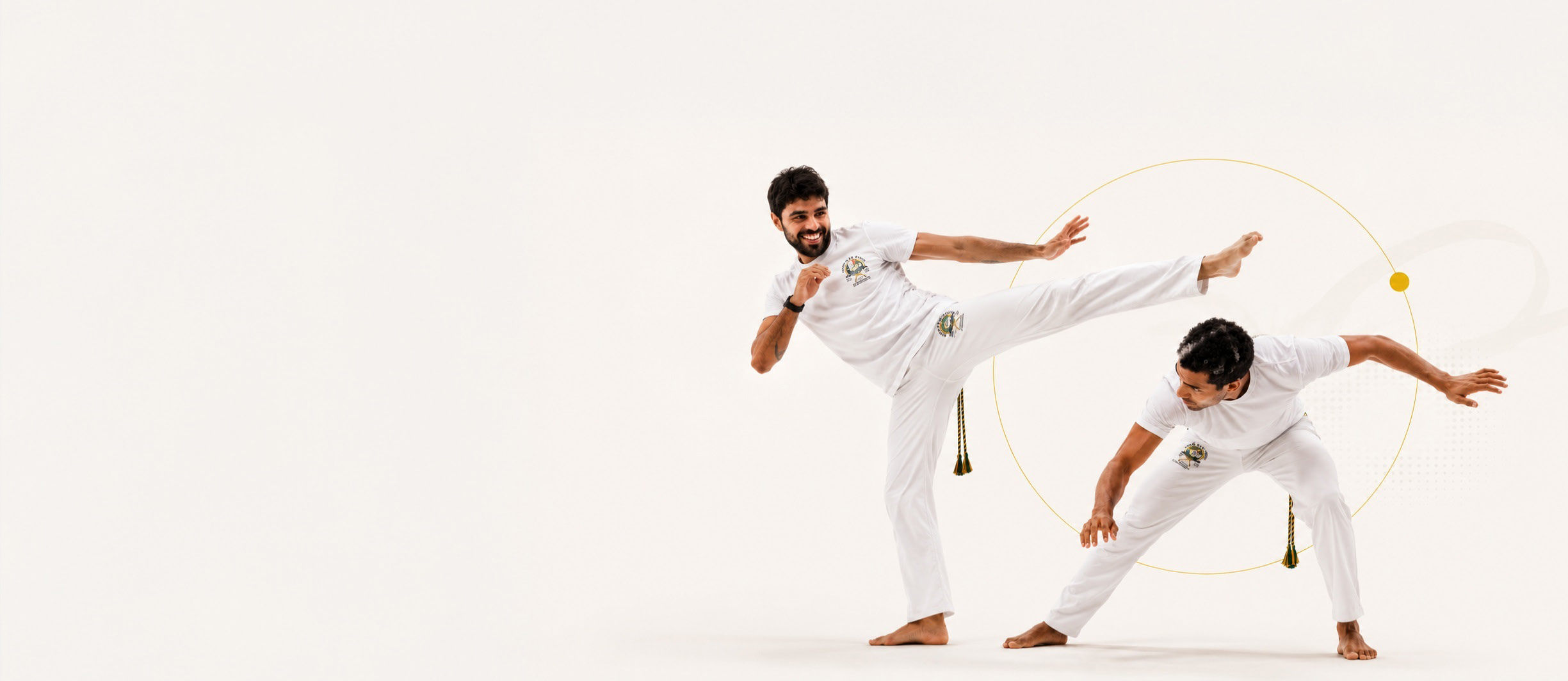 Deux capoeiristes en tenue blanche en plein mouvement